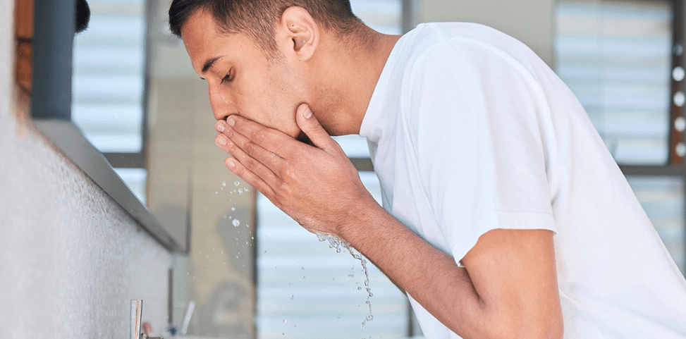 Person rinsing mouth at bathroom sink to relieve dental pain during a dental emergency consultation in Tarneit